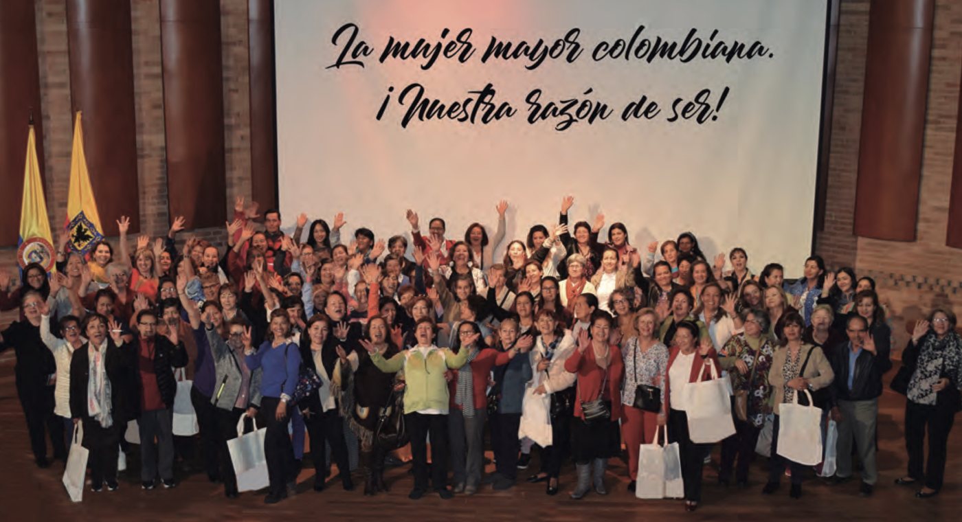 Grupo de mujeres saludando en un encuentro de ASOMENOPAUSIA en Bogotá, bajo el lema La mujer mayor colombiana, nuestra razón de ser