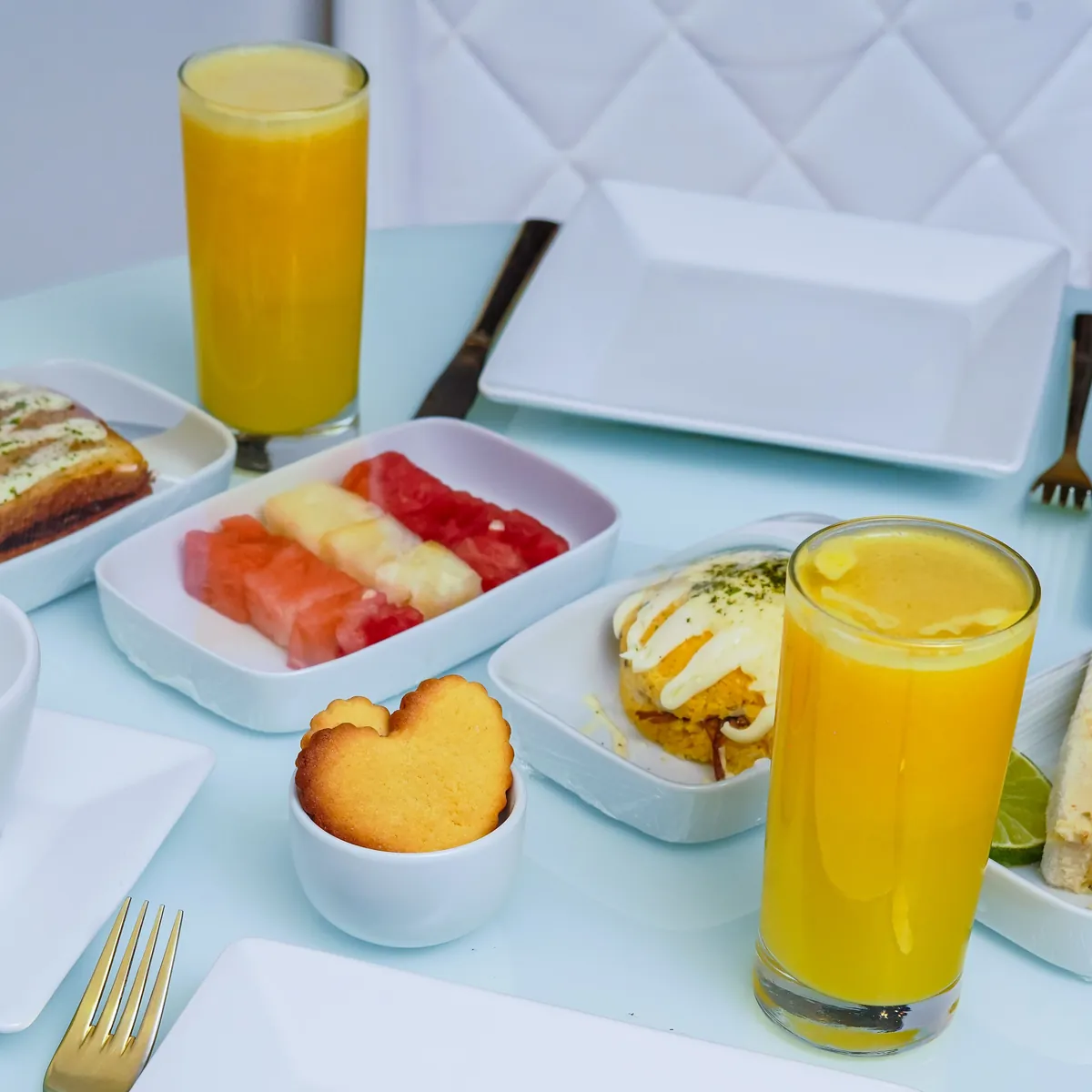 Desayuno con jugo natural, fruta picada y pan
